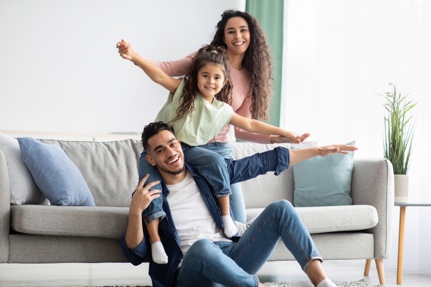 Parents playing with their daughter at home