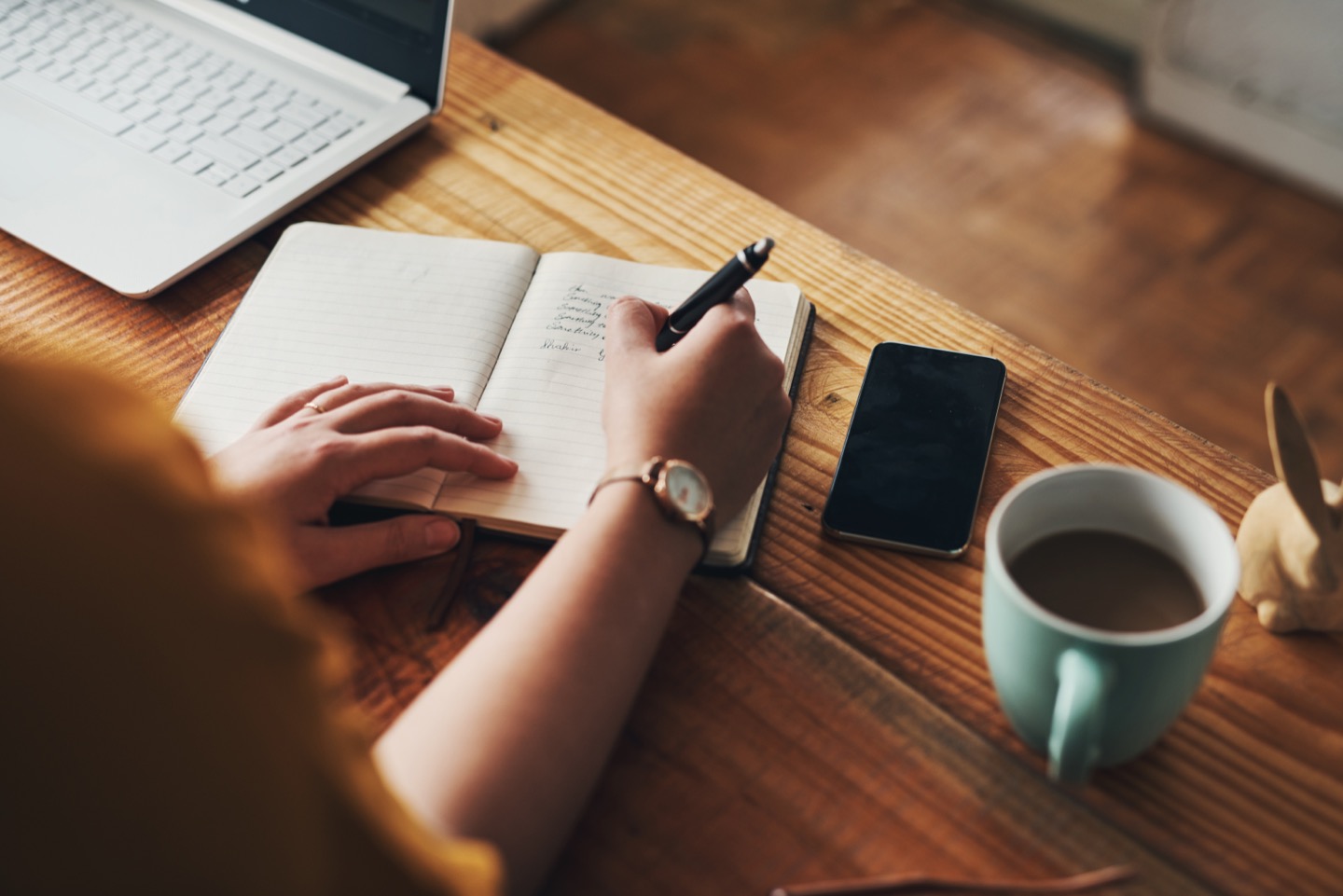 A notebook and laptop used to organise priorities